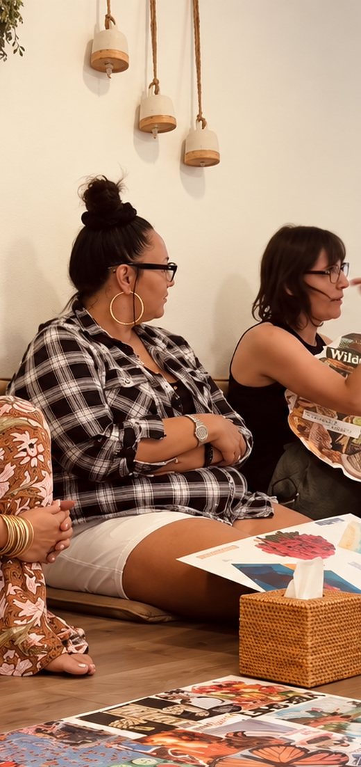 Two women making collages on the floor during a creative workshop